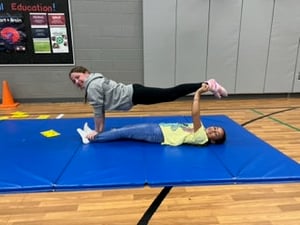 Students Working on Stunts & Tumbling in Physical Education Class