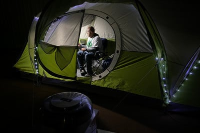 Mr. Brock in his tent looking at phone.