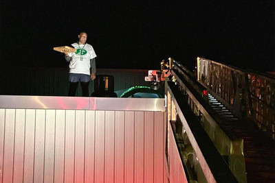 Mr. Brock on the roof with his pizza box.